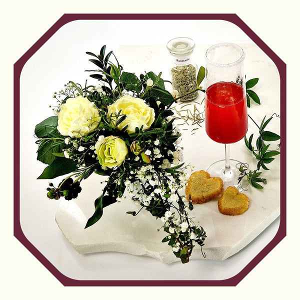 Rosmarin im Glas neben einem Sektglas mit Sekt und Rosmarin-Himbeer-Spritz, Rosmarin Scones in Herzform, Blumenstrauß