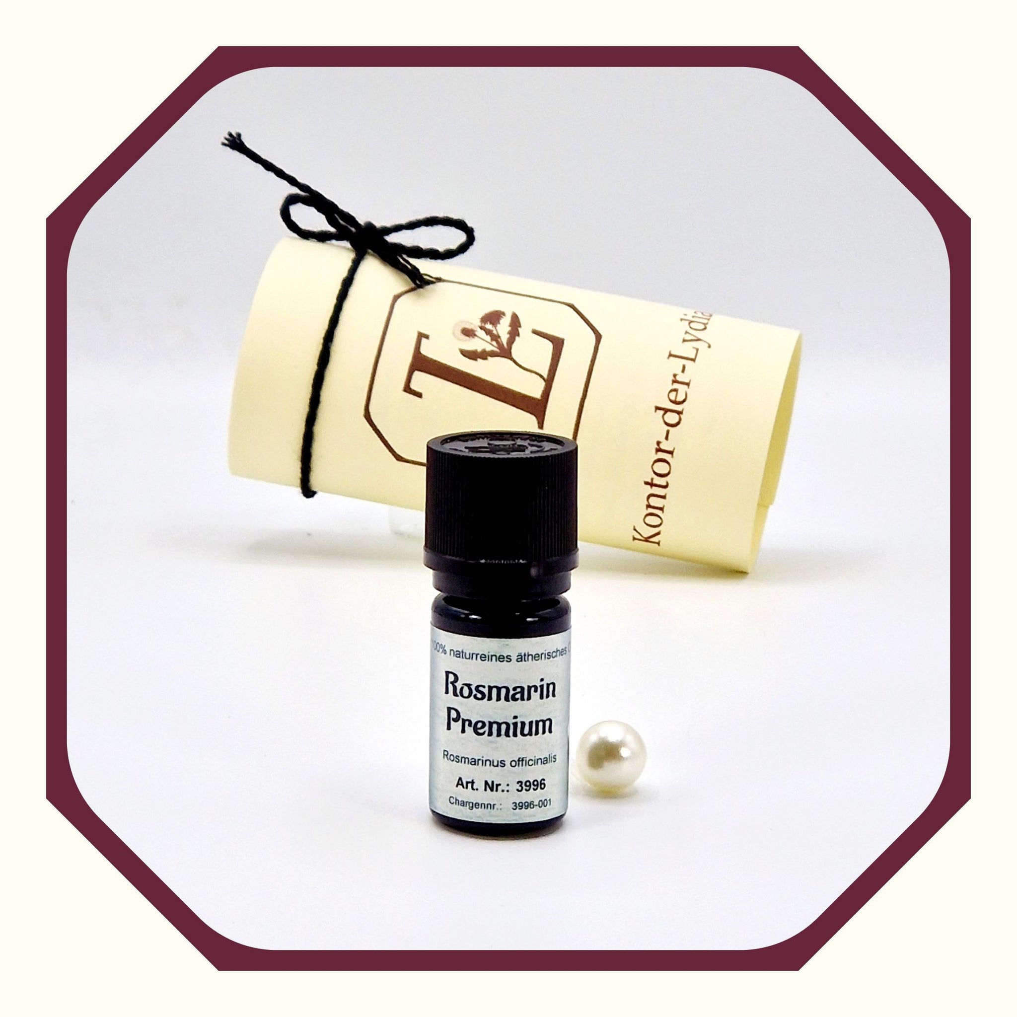 Eine Perle, eine rund gefaltete Karte mit schwarzem Schleifenband, eine Flasche Ätherisches Öl Rosmarin Premium